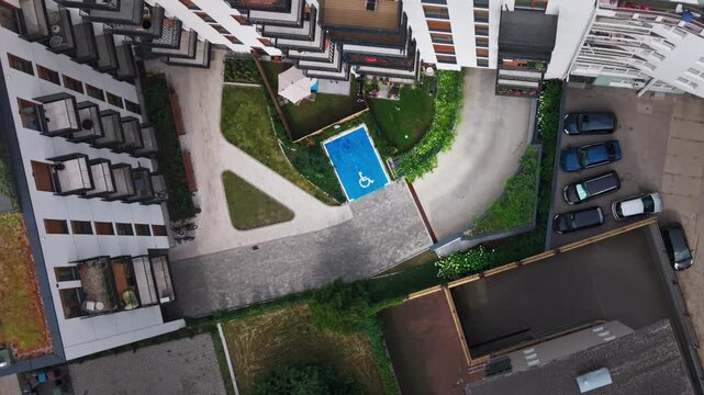 Aerial View Modern Apartment Building Courtyard Disabled Parking Space Blue Wheelchair Symbol, showing a high-angle top-down perspective of a new residential estate development