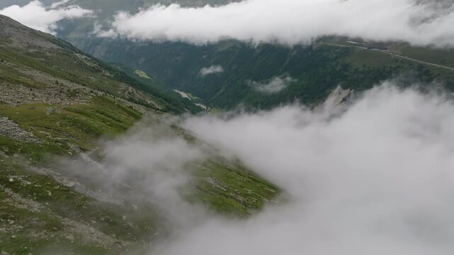 Stunning aerial panorama of Timmelsjoch in Tyrol featuring clouds floating above alpine mountains dramatic rocky valleys and scenic landscapes between Austria and Italy
