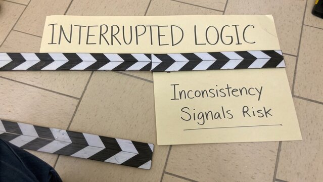 Creative Representation of Interrupted Logic with Clapper Board and Inconsistency Message on a Floor Background