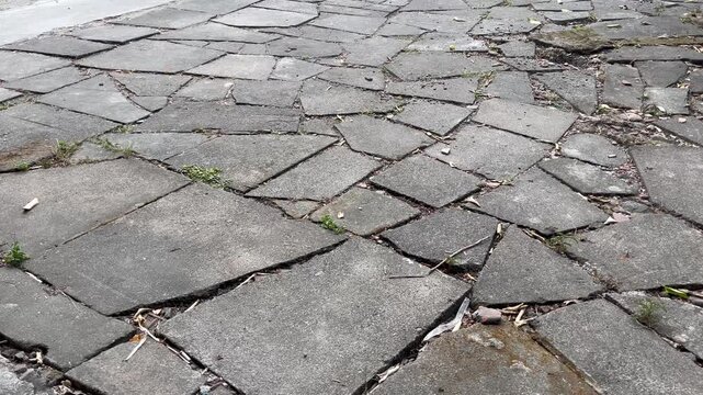 Damaged stone pavers texture with green grass cracks