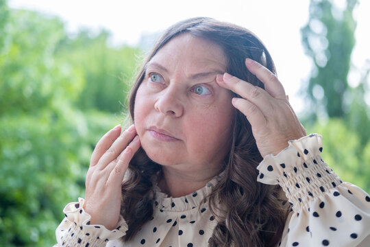 50 year old female with eye irritation, speck, Mature woman with tired eyes, optical discomfort, blurry vision problems, tired look, poor eyesight, aging, health care, close up view