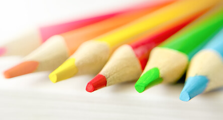 Fototapeta premium Colorful pencils on white sheet of paper. MACRO PENCILS