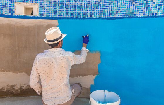 Paints the pool with blue paint. Selective focus.