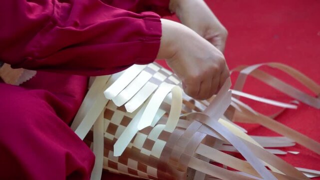 Making a woven bag out of plastic strips. A recycled bag.