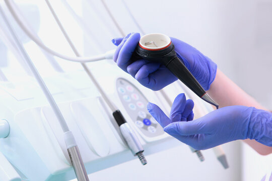 Sandblasting teeth cleaning. Device is in hands of doctor. Oral hygiene. An effective method of oral hygiene. Prevention of dental diseases.