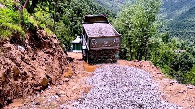 Dump Truck Spreading Gravel on Under Construction Road for Highway Infrastructure Development, Civil Engineering and Road Building Project Progress