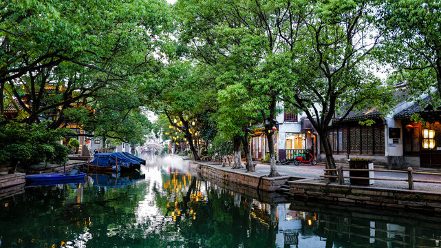 Evening scenery of stone arch bridge in Zhouzhuang Ancient Town, Jiangnan water town, traditional Chinese buildings with warm lantern lights and river water reflection