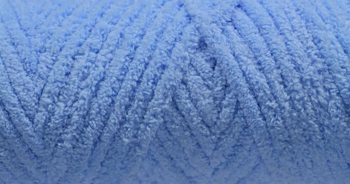 Blue fluffy yarn texture. Close-up soft chenille fabric with braided fluffy surface, smooth seamless loop motion. Ideal for fashion, cozy and textile backgrounds.  