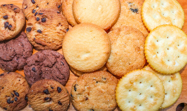 Close ip assorted cookies and biscuits. Collection of sweet baked snacks including chocolate cookies, butter biscuits, crackers and sandwich cookies