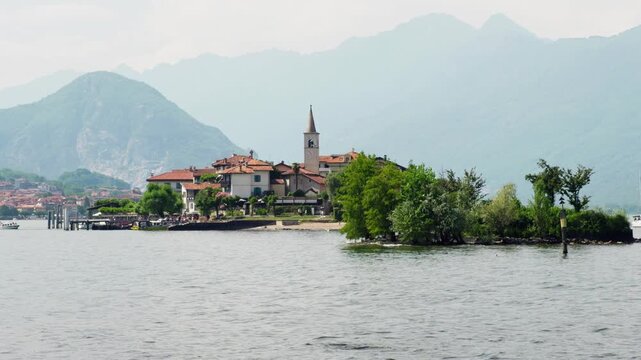 Majestic view of isola dei pescatori, one of the borromean islands on lake maggiore, with its picturesque village and the alps in the background