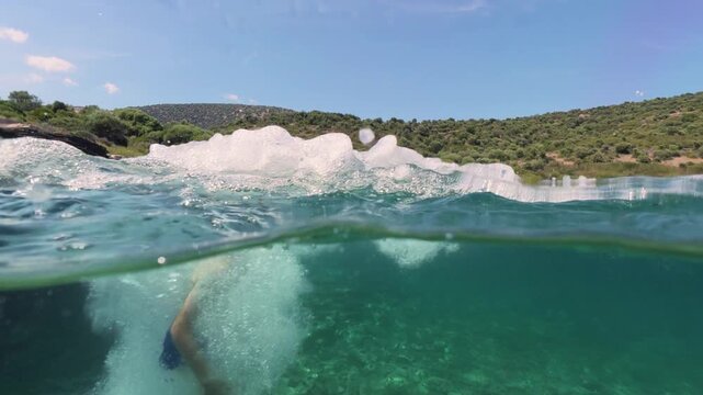 Split level view of a boy jumping into the sea water with splash