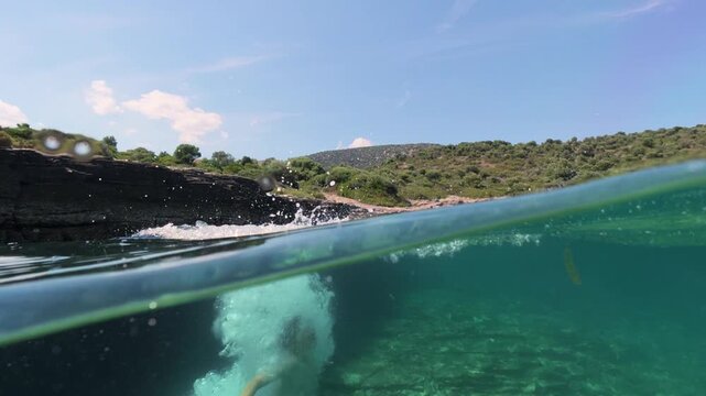 Split level view of a boys jumping into the sea water with splash
