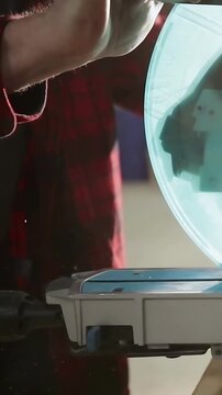 Vertical video: Entering, man in red plaid reaching and aligning teal dome onto gray base at table