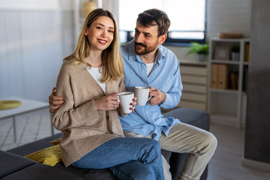 Happy couple enjoying morning coffee together at home, smiling and relaxing in a cozy atmosphere