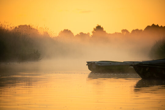 Boat on Misty River at Sunrise