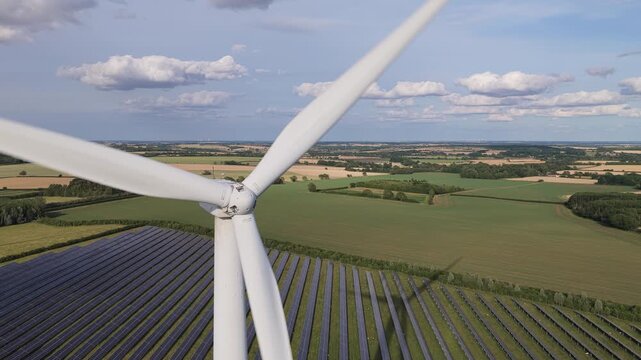 Rotating Wind Turbine Blades Above Solar Panel Array