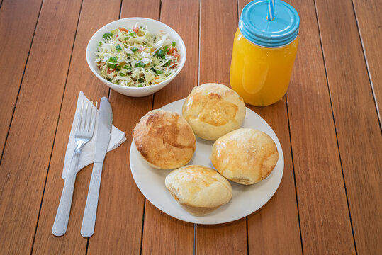 Brazilian empada snacks salad and juice on wooden table
