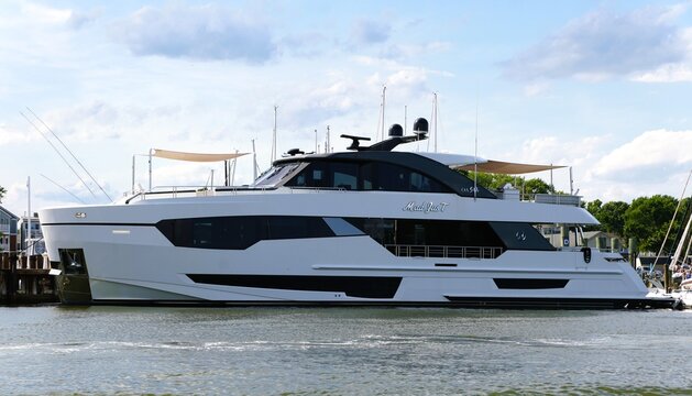 Annapolis, Maryland, U.S.A - Jun 12, 2026 - Modern luxury yacht 'Mad JusT' docked at marina, featuring sleek white hull, tinted windows, canopies and antennas