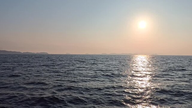 Real-time maritime sunrise footage under a clear sky with perfect copy space on choppy sea