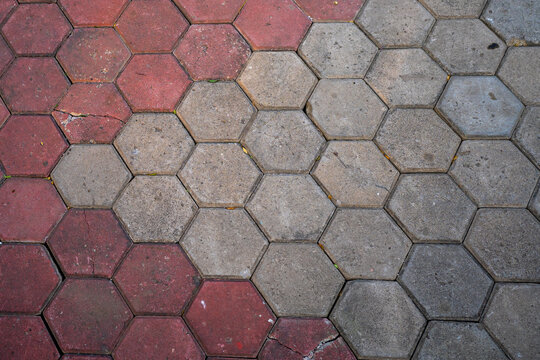 Red and grey hexagonal paving block tiles pattern on outdoor pedestrian sidewalk floor background
