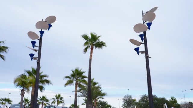 Beautiful modern city landscape featuring palm trees, street lamps, and a clear blue sky. Concept of urban lifestyle, city architecture, travel destination, sunny weather, and contemporary outdoor