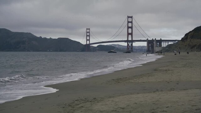 Foamy Waves Rolling Onto Beach Near Golden Gate Bridge In San Francisco - Wide Shot