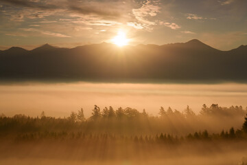 Obraz premium Sunrise over the Tokachi mountain range and sea of clouds from Senbo Pass in Kamifurano, Hokkaido, Japan