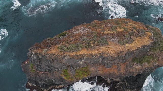 Spectacular top down aerial view of the volcanic cliffs and rock formations of Los Roques, with powerful ocean waves crashing against them