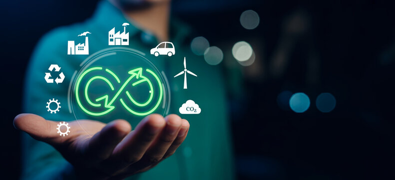 Hand holding digital interface with circular economy symbol and sustainability icons.