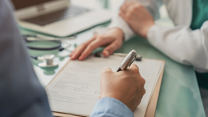 Doctor assisting patient with medical form