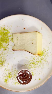 Cheesecake  San Sebasti&aacute;n   with   Chocolate Sauce Topping Served on a White Plate