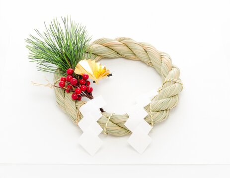 Japanese shimekazari New Year rope wreath decoration with white shide paper streamers isolated on a white background