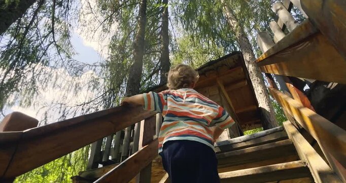 Slow Motion Of Toddler Climbing Wooden Playground Stairs Outdoors. Little child climbing wooden playground stairs in a park, developing balance, confidence and motor skills during outdoor play.