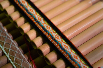 Naklejka premium Macro Detail of Traditional Andean Panflute with Woven Pattern