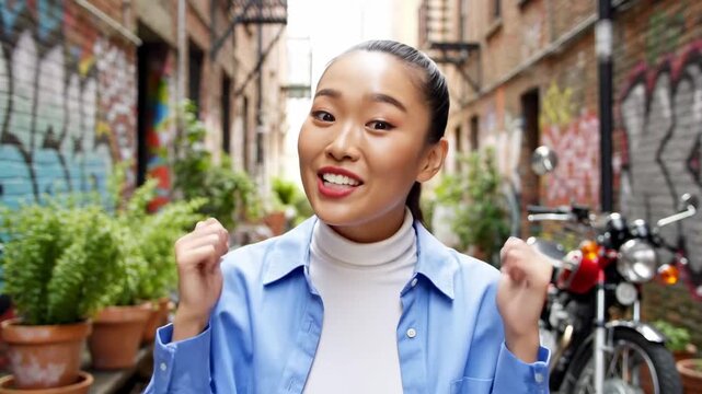 Surprised Young Asian Woman Expressing Excitement in Urban Alleyway with Graffiti and Motorcycle, Ideal for Lifestyle Vlogs or Social Media Marketing.