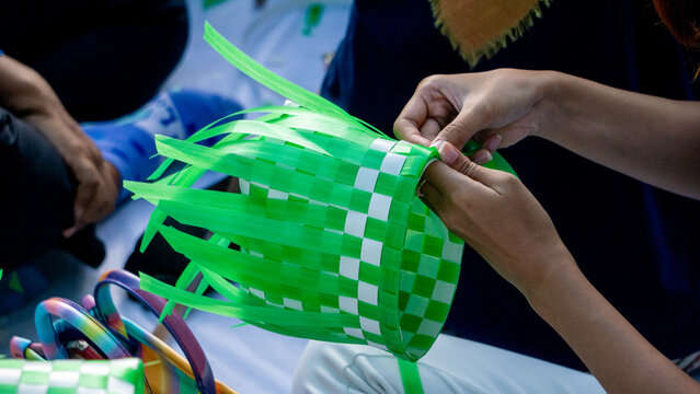 Making a woven bag out of plastic strips. A recycled bag.