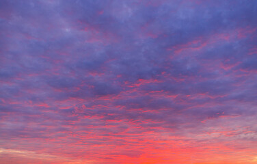 Fototapeta premium Stunning Sunset Sky with Vibrant Purple and Orange Clouds,A breathtaking view of a dramatic sunset sky filled with vibrant purple and fiery orange clouds, creating a peaceful and inspiring atmosphere.