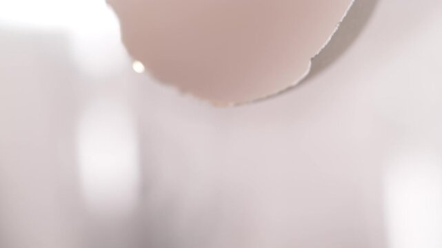 Macro Egg Yolk Sliding Out of Cracked Eggshell in Slow Motion
