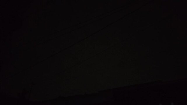 Vibrant Forked Lightning Bolt Striking Across a Dark Stormy Night Sky Over a Silhouetted Urban Landscape