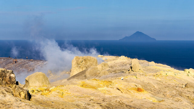 Volcanic fumaroles with sulfur deposits on Vulcano island with Filicudi in the background, Italy