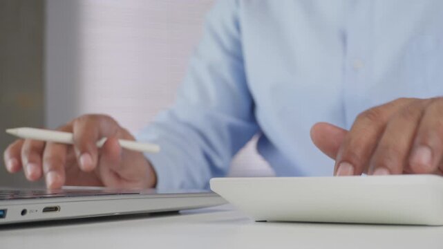Professional hands using calculator and laptop simultaneously, financial analysis, accounting, budgeting, office work, illustrating business productivity, data management, modern workplace efficiency