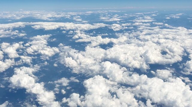 View of White Clouds from an Airplane Window During a Flight at High Altitude