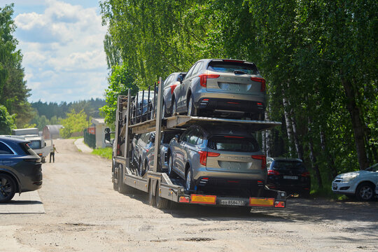 Minsk, Belarus. May 15, 2026. Multi level vehicle hauler truck packed with new Haval Jolion passenger automobiles in transit on sunny day on rural dusty road. Dealership delivery, vehicle distribution