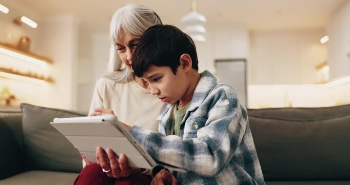 Grandma, child and tablet in house for learning, play game and bonding together on weekend. Tech, smile and boy with grandparent on sofa for educational gaming, scroll app and online development