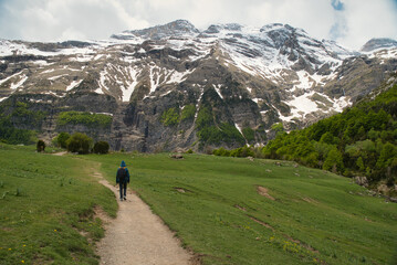 Obraz premium A young girl hiking alone in the Pyrenees, Pineta Valley, Monte Perdido, Camino de los Llanos de la Larri, Aragón, Huesca, Spain