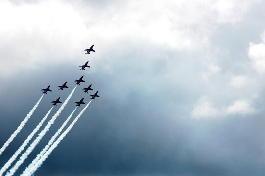 The Red Arrows flying in concorde formationwith smoke trails against a cloudy sky