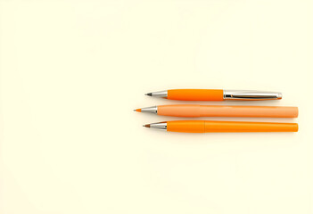Obraz premium Three orange pens flat lay on light background