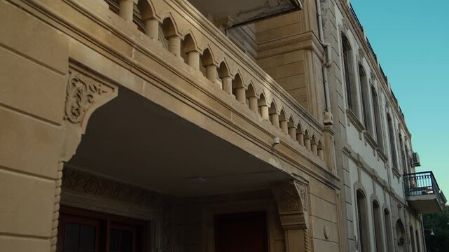 Close-up Pan of Historic Stone Building Facade with Ornate Balcony