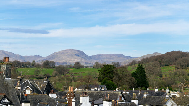 A view of rooftops and hills in the village of Hawkshead in the Lake District, England. A view of the mountain from the village hill