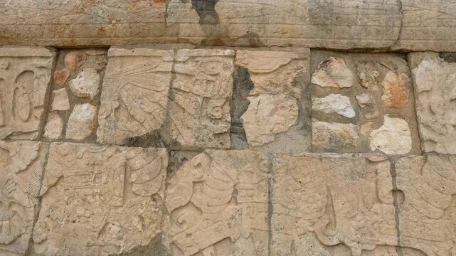 Ancient stone carvings on walls of Great Ball Court in Chichen Itza, Mexico. Detailed Mayan reliefs at historic stadium. Archaeology, heritage, culture and travel destination concept.
